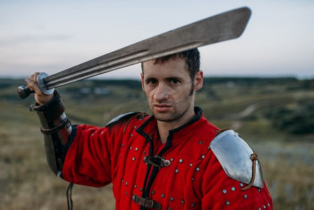 金属头盔的中世纪骑士拿着剑,伟大的战斗.足球运动人物特写