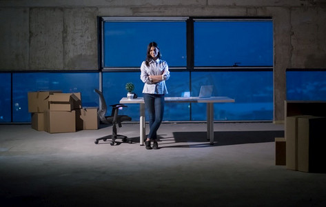 流程摄影照片_年轻女建筑师的肖像在建筑工地使用膝上型计算机检查文件和业务工作流程在新的启动办公室