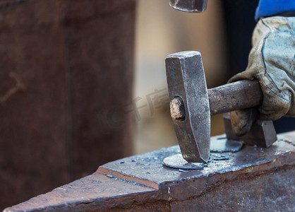 铁匠在铁锤上手工锻造熔化的金属