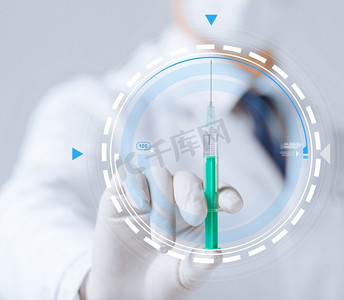 麻醉摄影照片_医疗保健与医学概念-S医生手持注射器虚拟投影特写。医生和S手持注射器的特写