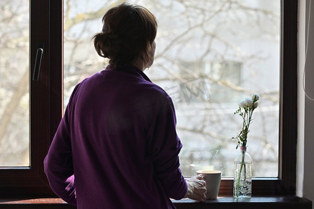A Self—isolated Woman or Isolated Woman Looking Out of Window Home