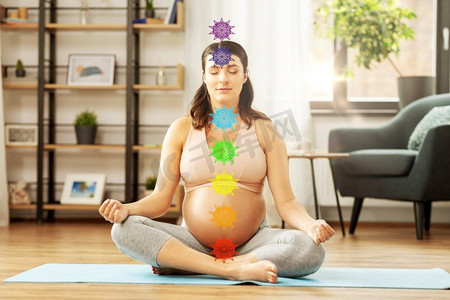 瑜伽，冥想和正念概念-快乐的孕妇在家冥想七个脉轮符号。孕妇在家中冥想