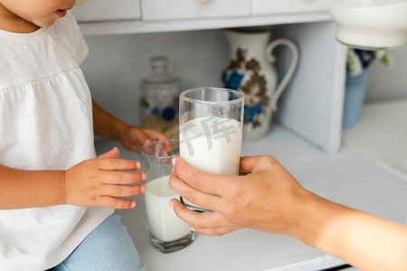 母亲手中拿着玻璃牛奶。高分辨率照片。母亲手中拿着玻璃牛奶。高质量照片