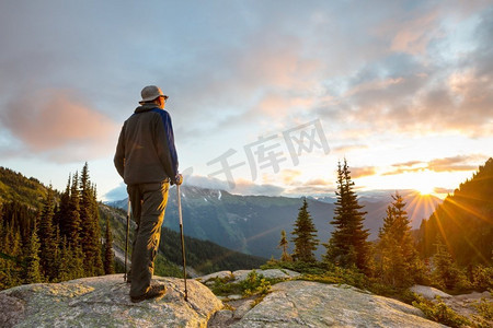 登山徒步的人摄影照片_徒步旅行场景在美丽的夏天山在日落