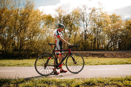 骑自行车的头盔和运动服，cycrocrocross训练在柏油路。男运动员骑自行车。在自行车道上锻炼
