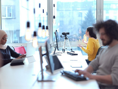 商务女性在现代开放空间合作办公室举行在线会议，作为影响者制作播客或教程视频