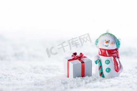 圣诞和新年雪人和礼物在白色的雪地上。圣诞雪人和礼物