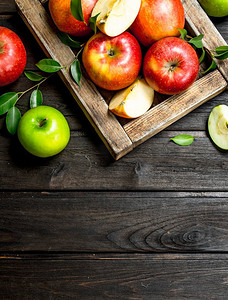 原框摄影照片_红苹果和绿苹果放在木箱里。在一个黑暗的木制背景。红苹果和绿苹果放在木箱里。
