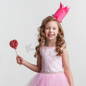 美丽的小糖果公主，戴着皇冠，戴着大粉心棒棒糖。糖果公主女孩配棒棒糖