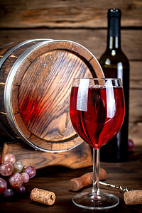 桌子上的玻璃杯里放着陈年葡萄酒。在一个木制的背景下。桌子上的玻璃杯里放着陈年葡萄酒。 