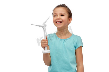 可持续能源、电力和人的概念-白色背景下带着玩具风力涡轮机的快乐微笑女孩。带着玩具风力涡轮机的微笑女孩