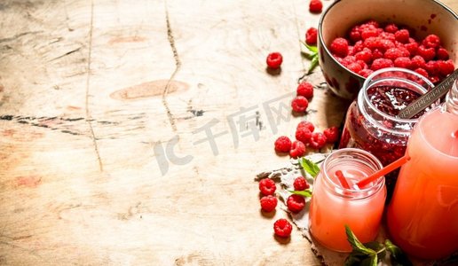红色一张摄影照片_新鲜覆盆子和果酱的汁液。在一张木桌上..新鲜覆盆子和果酱的汁液。