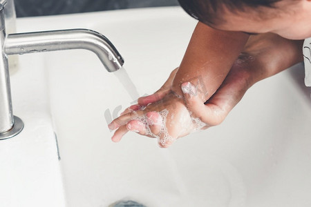 欧式洗手池摄影照片_母亲洗手以预防新型冠状病毒病2019或COVID—19。人们在洗手池洗手以清除病毒感染。
