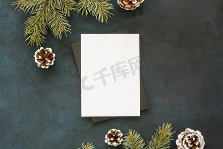 圣诞邀请摄影照片_一张被松树叶包围的白纸
