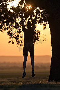 耶稣祈祷摄影照片_特写肖像年轻男子在日落时独自跳跃