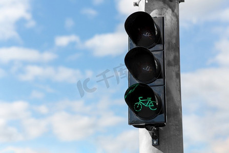 道路和信号概念—绿色交通灯在蓝天的自行车特写。蓝天自行车绿色交通灯
