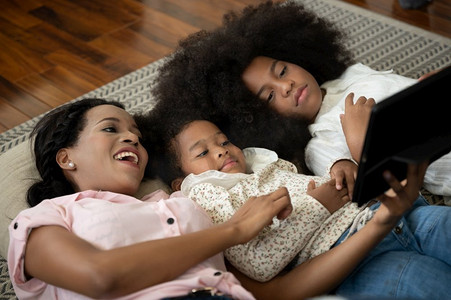非洲裔美国人母亲和女儿观看媒体在平板电脑