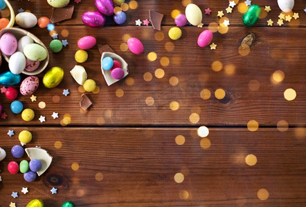 复活节，糖果和糖果概念—巧克力蛋和糖果滴在木背景。巧克力蛋和糖果滴在木桌上