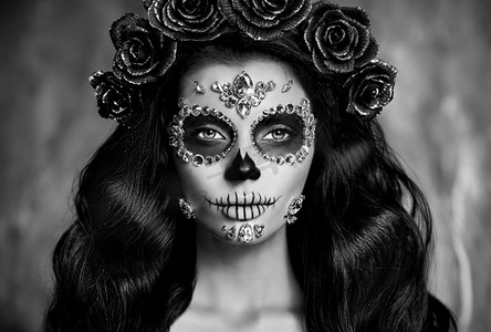 一个女人的肖像，在黑色的背景上涂着糖头骨的妆。万圣节服装和化妆。卡拉维拉·卡特里娜的肖像