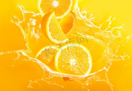 新鲜的橙子落在果汁里，溅起了很多巨大的水花
