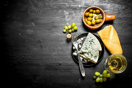 白葡萄酒配有美味的奶酪和美味的橄榄。白葡萄酒配有美味的奶酪和美味的橄榄。