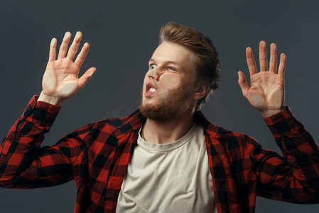 年轻人滑稽的脸庞压在透明玻璃上.足球运动美女