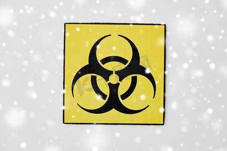 生物危害摄影照片_科学，有毒和流行病概念—生物危害警告标志在白色背景在冬天超过雪。生物危害警告标志在白色背景