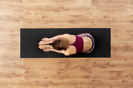 健身，运动和健康的生活方式概念—妇女做瑜伽练习垫在工作室。妇女做瑜伽练习垫在工作室