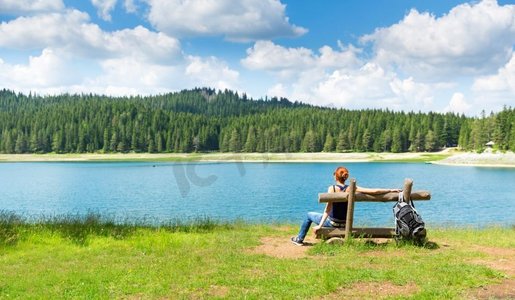 一位女旅行者在湖边的长凳上休息。杜尔米托尔国家公园