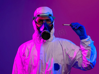 疾病防疫摄影照片_冠状病毒，医生手持新冠肺炎病毒阳性血样管。戴着生物危害防疫面具，穿着西装，发光。