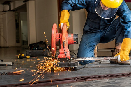 专业的机械师是用旋转金刚石刀片切割钢金属。钢铁工业和车间概念。