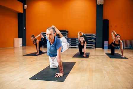 瑜伽伸展训练，有教练的女性团体，脂肪燃烧运动，健身房锻炼。瑜伽室内