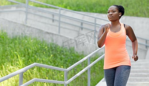 健身、运动和健康的生活方式理念--年轻的非裔美国女性在楼下跑步。年轻的非洲裔美国女性跑下楼来