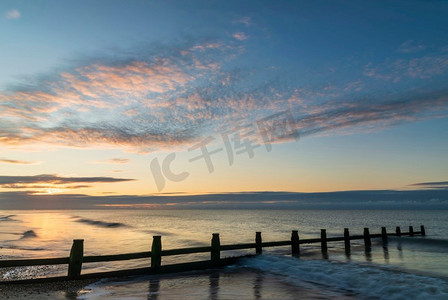 敦煌飞天云纹摄影照片_令人惊叹的充满活力的日出在英国南部海岸的海滩景观