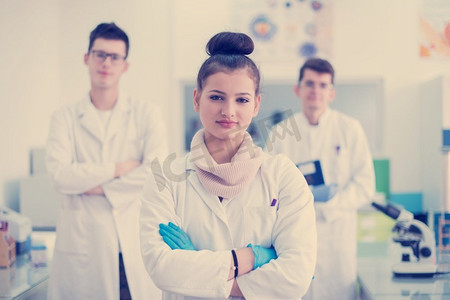 一群年轻的医学生站在一起的肖像在化学实验室，由大学生在室内的团队合作