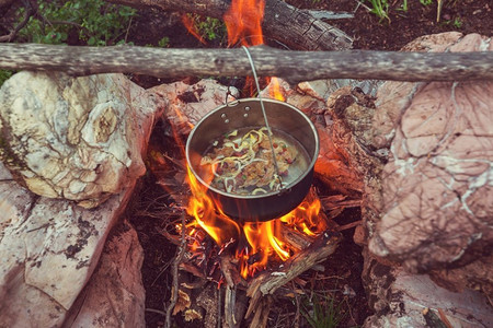 徒步旅行中野营时烧篝火的旅游水壶。在森林里用木柴做饭。