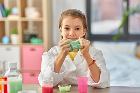 科学，童年和化学概念—女孩玩粘液在家庭实验室。女孩玩粘液在家里实验室