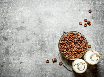 小麦麦片摄影照片_健康早餐巧克力麦片加牛奶。在石桌上。健康早餐巧克力麦片加牛奶。