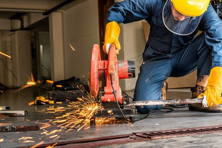 专业机械师正在用旋转金刚石刀片切割机切割钢金属.钢铁工人街道
