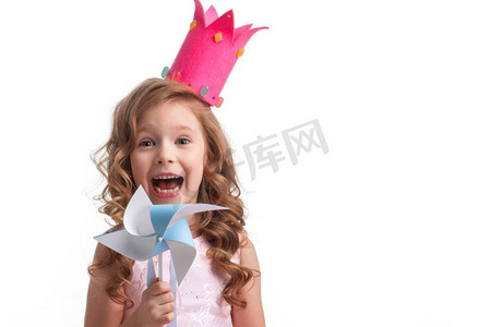 丝带小摄影照片_美丽的小糖果公主女孩在冠拿着风车和微笑。糖果公主女孩与风车