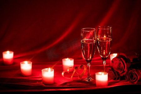 情人节背景与香槟杯玫瑰蜡烛和心。香槟杯和蜡烛