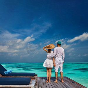 夫妇在白色的热带海滩码头在马尔代夫