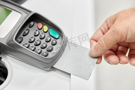 购物、支付和金融概念-与读卡器中的信用卡近距离接触。与读卡器中的信用卡近距离握手