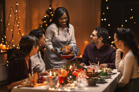 节日和庆祝概念—多民族的快乐朋友在家里吃圣诞晚餐。快乐的朋友在家里吃圣诞晚餐
