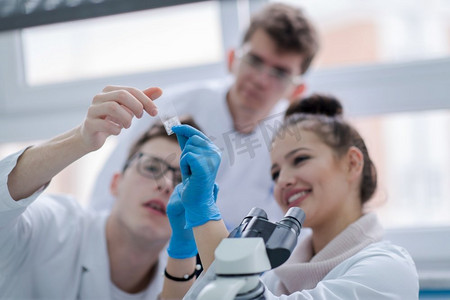一群年轻的医学生在化学实验室一起做研究，大学生在室内团队合作
