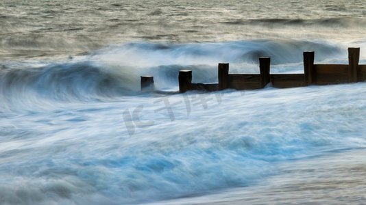 美丽的抽象长曝光风景图像波浪撞击到groynes在海滩在日落期间