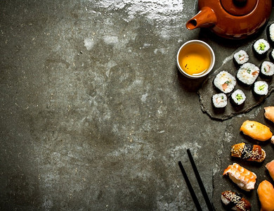 日本料理。寿司卷和一杯茶。在石桌上。日本料理。寿司卷和一杯茶。