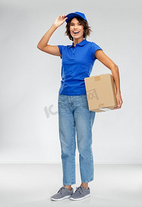 包裹快递的摄影照片_邮件服务和装运概念—有包裹盒的愉快的微笑的送货妇女在灰色背景快乐的微笑送货妇女与包裹盒