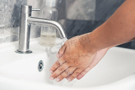 新型冠状病毒感染预防要点摄影照片_洗手以预防新型冠状病毒病2019或COVID—19。人们在洗手池洗手以清除病毒感染。