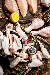 各种类型的生鸡肉与草药在木背景各种类型的生鸡肉与香草在一个碗。